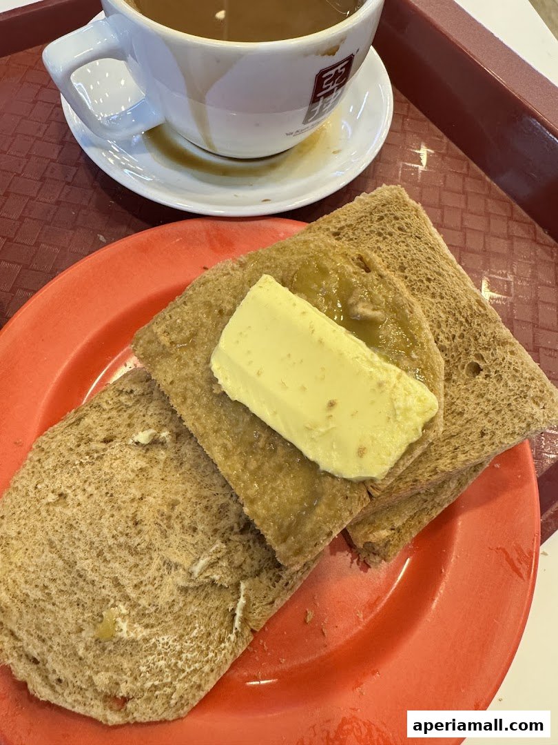A close-up of Ya Kun Kaya Toast's signature kaya toast with butter and a cup of coffee.