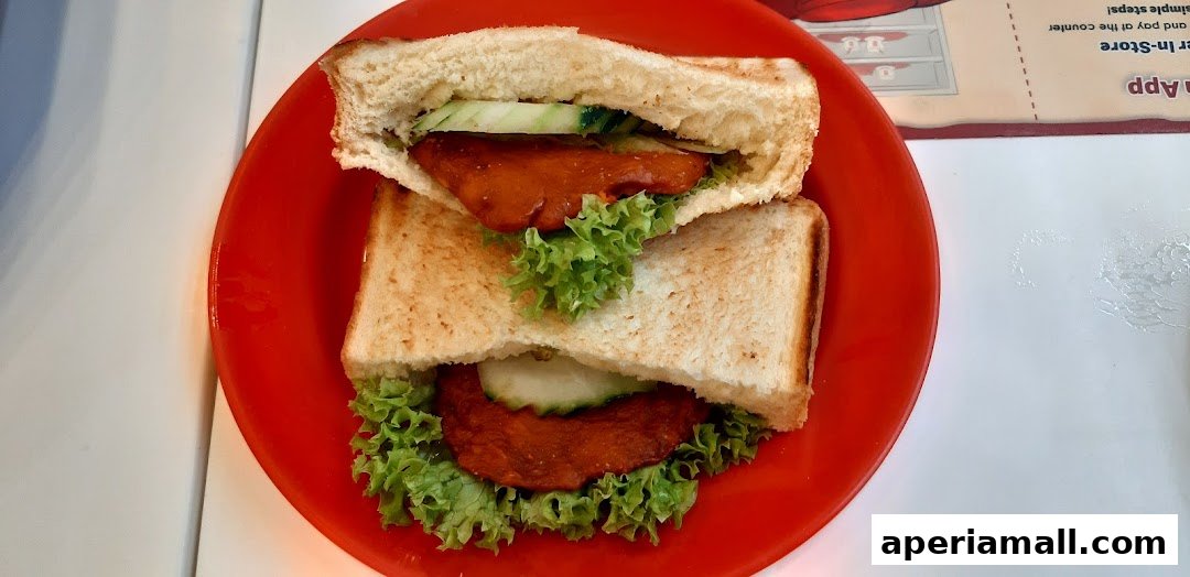A close-up shot of a sandwich with lettuce, cucumber, and a meat patty on a red plate.